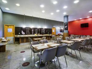 a restaurant with tables and chairs and a counter at ibis Vitoria Praia de Camburi in Vitória