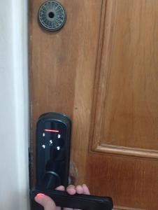 una persona que sostiene un teléfono celular frente a una puerta en Apartamento para 4 personas, en Asunción