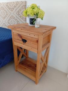 Una mesita de noche de madera con una planta en maceta encima. en Apartamento para 4 personas, en Asunción