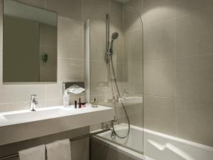 a bathroom with a shower and a sink and a mirror at AppartHotel Mercure Paris Boulogne in Boulogne-Billancourt
