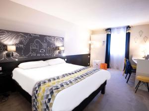 a bedroom with a bed with a chalkboard wall at Ibis Styles Cognac in Châteaubernard