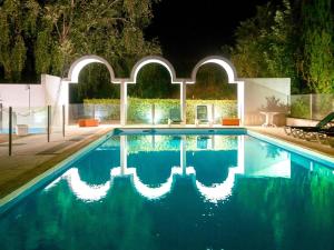 a swimming pool in a backyard at night at Ibis Styles Cognac in Châteaubernard