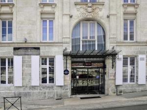 una tienda frente a un edificio en una calle en Mercure Angoulême Hôtel de France, en Angulema