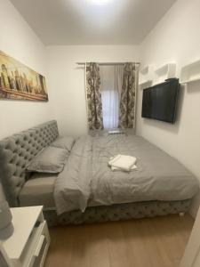 a bedroom with a bed and a flat screen tv at Apartman 601 in Surčin