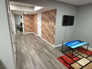 a living room with a table and a tv on a wall at Peaceful 1BHK - Maple in Edmonton