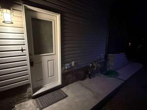 a door to a house at night next to a house at Peaceful 1BHK - Maple in Edmonton