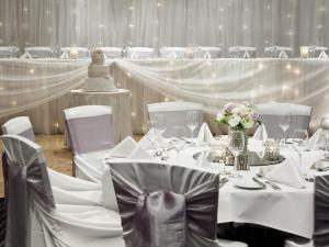 a banquet hall with white tables and chairs and a wedding cake at Pullman Sydney Hyde Park in Sydney +62 photos
