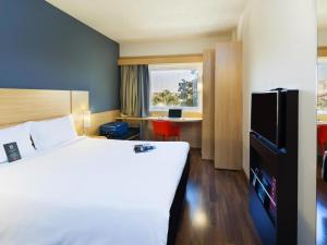 パウリニアにあるibis Pauliniaの大きなベッドと机があるホテルの部屋