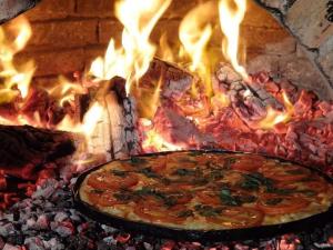 a pizza is cooking in a brick oven at Pousada Fruto de Itaúna in Saquarema