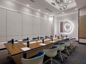 ラヨーンにあるNovotel Rayong Star Convention Centreの長いテーブルと椅子のある大きな会議室