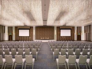 ラヨーンにあるNovotel Rayong Star Convention Centreの椅子・スクリーンが設置された空講堂