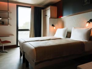 Una habitación de hotel con dos camas y una ventana. en ibis Styles La Rochelle Centre Gare, en La Rochelle