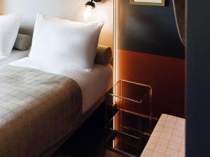 Un dormitorio con una cama y una mesita de noche con una almohada. en ibis Styles La Rochelle Centre Gare, en La Rochelle 155 fotos más