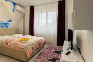 Un dormitorio con una cama y un escritorio con televisión. en Ho-Jack Dream Studio, en Roşu