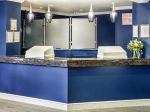 a blue room with a counter with blue walls and lights at Mercure Swansea Hotel in Swansea