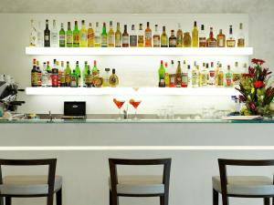 un bar avec trois chaises et des bouteilles d'alcool dans l'établissement Mercure Hotel Rimini Artis, à Rimini