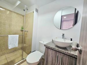 a bathroom with a toilet and a sink and a mirror at Apartamento familiar en Armenia Q in Armenia +22 photos