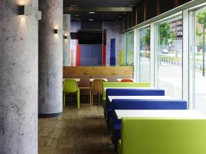 a dining room with colorful tables and chairs at ibis budget Zurich City West in Zürich