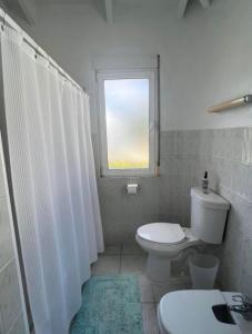 Un baño blanco con inodoro y ventana. en Green Cay - Walk to the Beach - King Bed - AC, en Christiansted