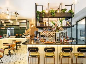 a bar in a restaurant with chairs and tables at Mercure Singapore Tyrwhitt in Singapore