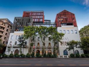 two tall buildings with trees in front of a street at Tbilisi Philharmonic Hotel by Mercure in Tbilisi City
