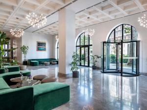a lobby with green furniture and large windows at Tbilisi Philharmonic Hotel by Mercure in Tbilisi City