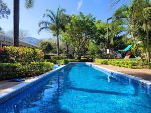 a swimming pool with blue water and palm trees at Near Airport - Lush Gardens, Pool, King Bed, Security in Santa Ana