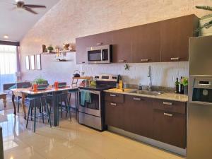 a kitchen with brown cabinets and a table in it at Near Airport - Lush Gardens, Pool, King Bed, Security in Santa Ana