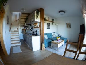 Una cocina y una sala de estar con un sofá azul. en Apartmán Schwaderbach, en Bublava