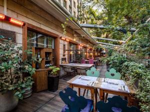 トビリシにあるMercure Tbilisi Old Townの屋外パティオ(テーブル、椅子、植物付)