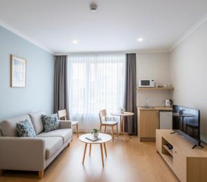 una sala de estar con un sofá y una mesa en Yenibir Apart, en Alejandreta