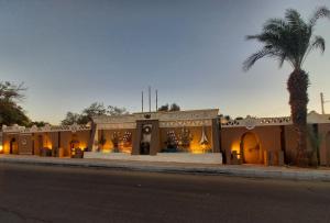 a store on the side of a street with a palm tree at Lotus 蓮 in Abu Simbel