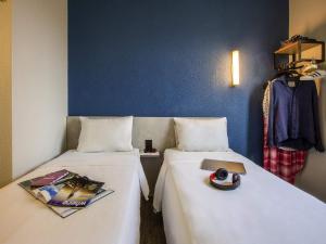 two beds sitting next to each other in a room at ibis budget Sao Paulo Morumbi in Sao Paulo