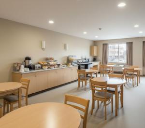 una cafetería con mesas y sillas y una cocina en Yenibir Apart, en Alejandreta 13 fotos más