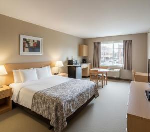 Una habitación de hotel con una cama grande y un escritorio. en Yenibir Apart, en Alejandreta