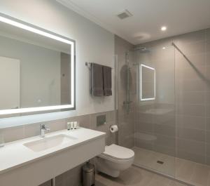 Un baño con inodoro, lavabo y ducha. en Yenibir Apart, en Alejandreta