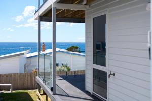 una casa con vista sull'oceano dal portico di Bicheno Ocean Views Apt 2 a Bicheno