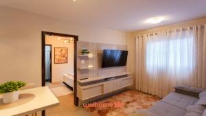 a living room with a flat screen tv on a entertainment center at Apartamento em Londrina no Centro da cidade in Londrina