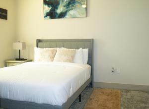 a bedroom with a bed with white sheets and pillows at New! The Vibe Med Center Apartments - Central Houston in Houston +32 photos