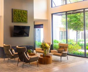 a lobby with chairs and a flat screen tv at New! The Vibe Med Center Apartments - Central Houston in Houston