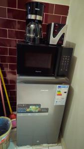 a microwave sitting on top of a refrigerator at Rockville Building Studio Meuble Guest House in Yaoundé