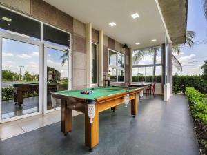 a pool table in the middle of a room with windows at ibis Sorocaba in Sorocaba