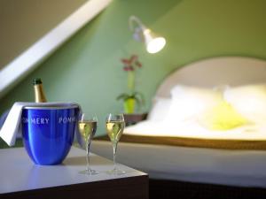 two glasses of wine on a table in a bedroom at Mercure Strasbourg Centre Gare in Strasbourg
