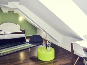 a bedroom with a bed and a chair and a table at Mercure Strasbourg Centre Gare in Strasbourg