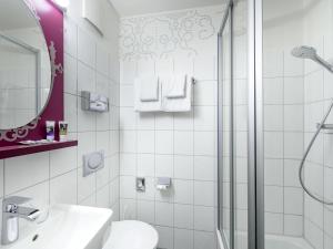 a white bathroom with a sink and a shower at Mercure München am Olympiapark in Munich +45 photos