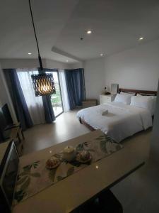 a bedroom with a bed and a table with food on it at El Paseo Tambuli in Maribago