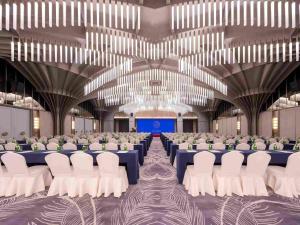 ein großer Saal mit Sitzreihen und einer Bühne in der Unterkunft Mercure Hangzhou Xixi Zijingang in Hangzhou