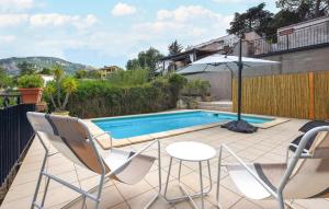 a patio with chairs and an umbrella next to a swimming pool at Gorgeous Home In Caccamo With Private Swimming Pool, Can Be Inside Or Outside in Caccamo