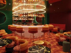 a room with a bar with stools and a bunch of bottles at Mama Shelter Rennes in Rennes