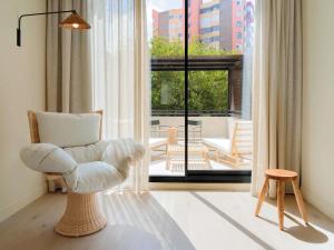 ein Wohnzimmer mit einem Stuhl und einem großen Fenster in der Unterkunft Mercure Benidorm in Benidorm